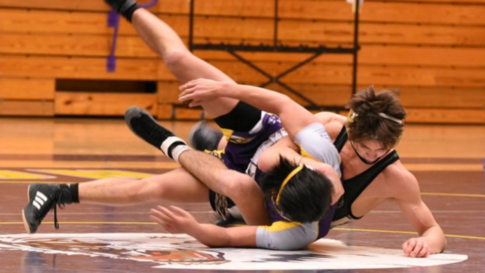 men on the floor during a wrestling match